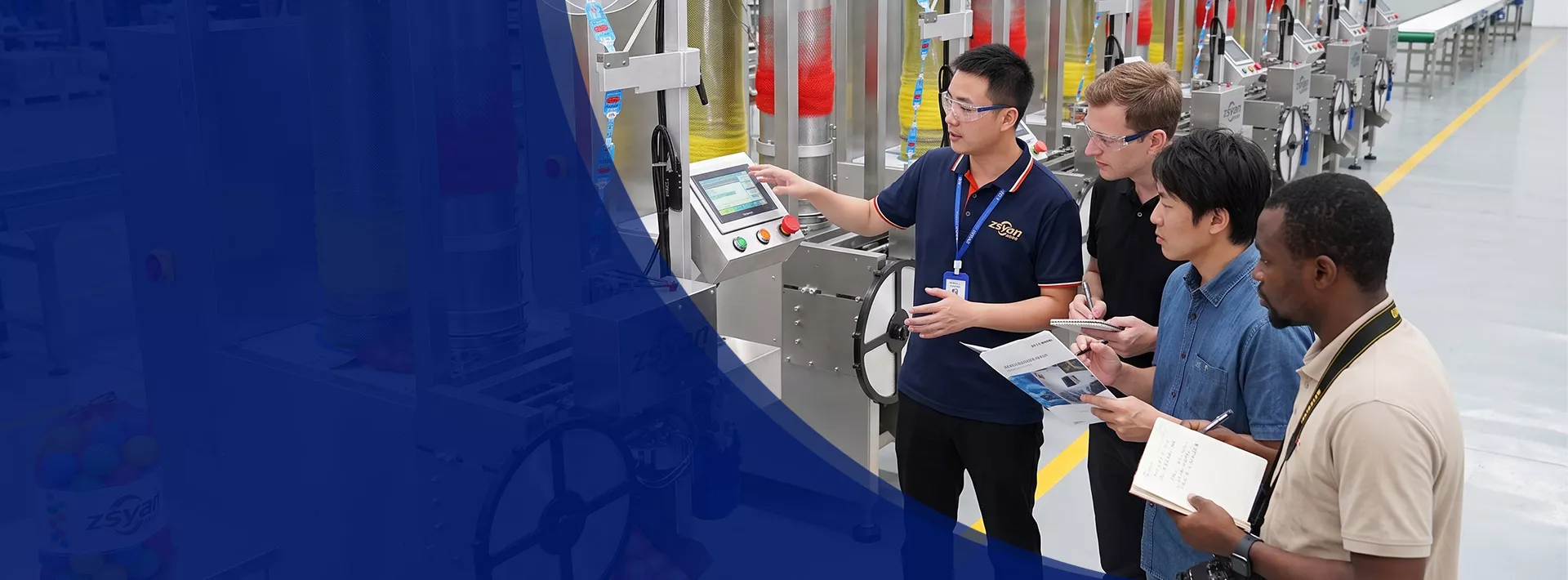 ZSYAN staff introducing automated manufacturing equipment to an international team in a factory workshop